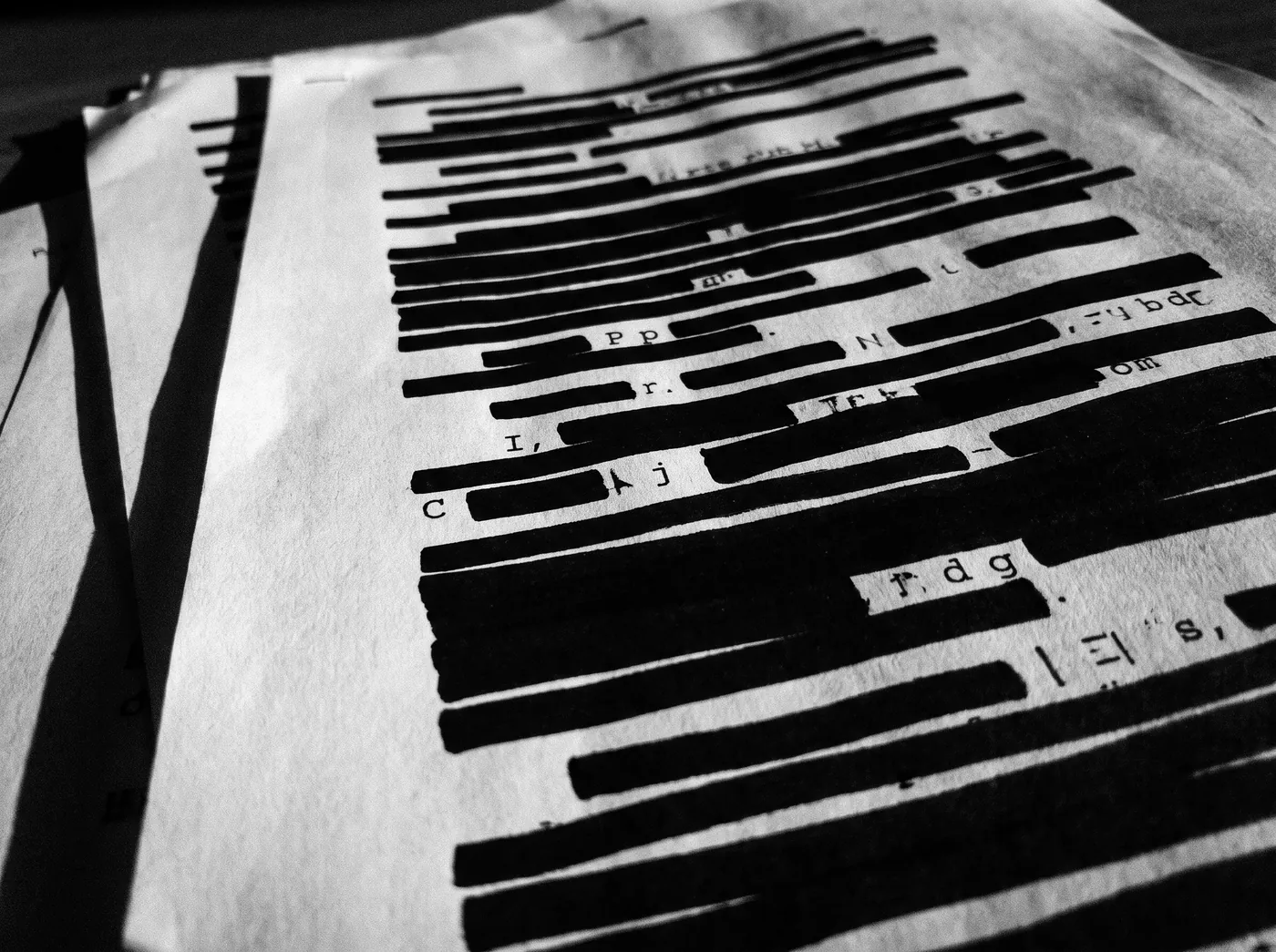 Documents covered in black redaction bars